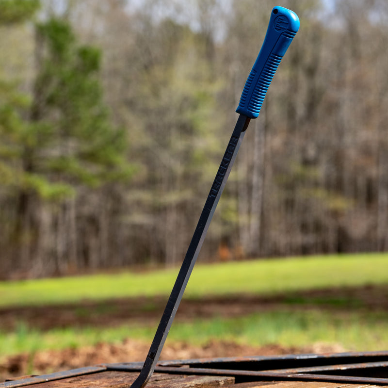 Blue-handled black Tracker probar tool leaning outdoors against wood